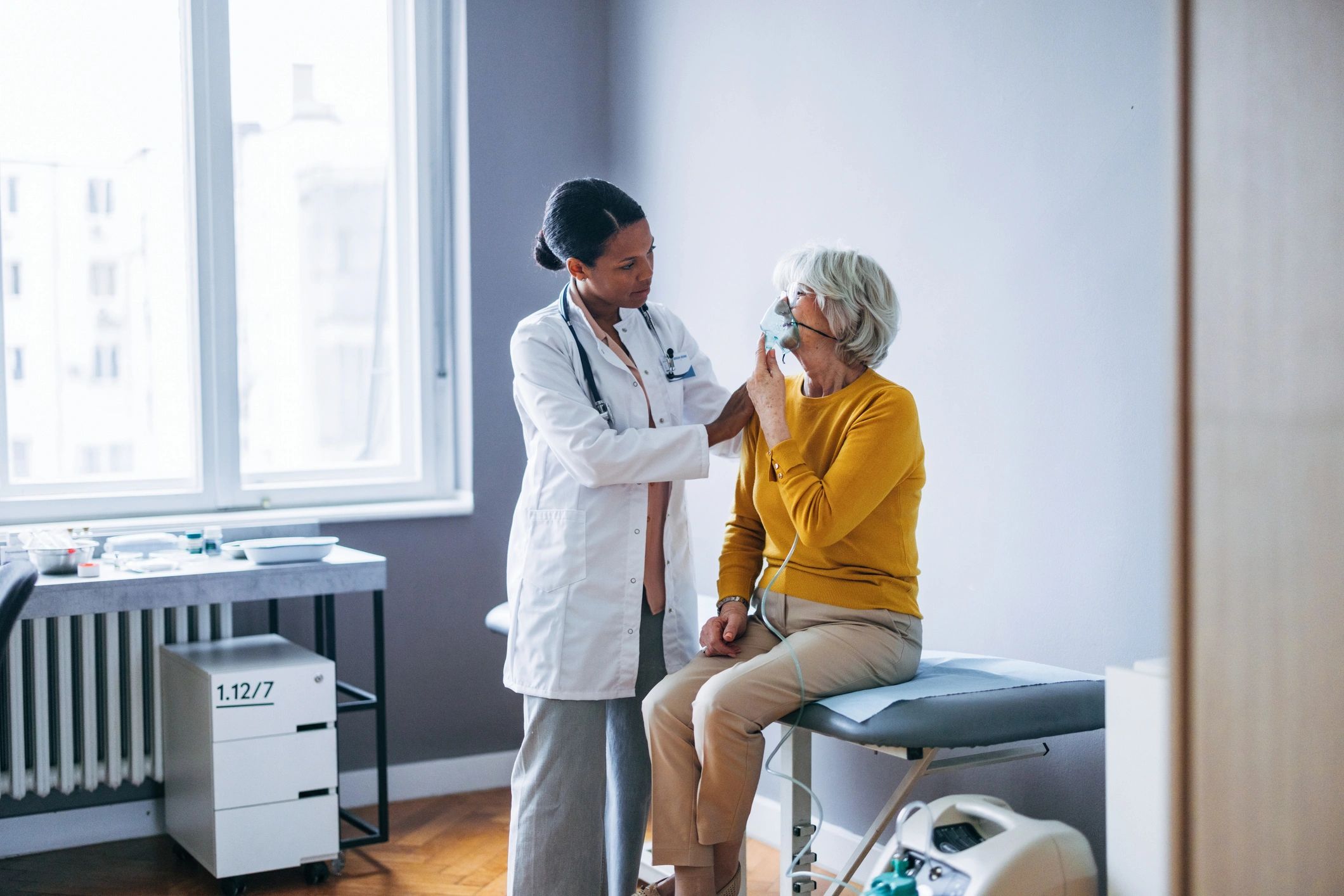 Doctor examining elderly woman in medical office